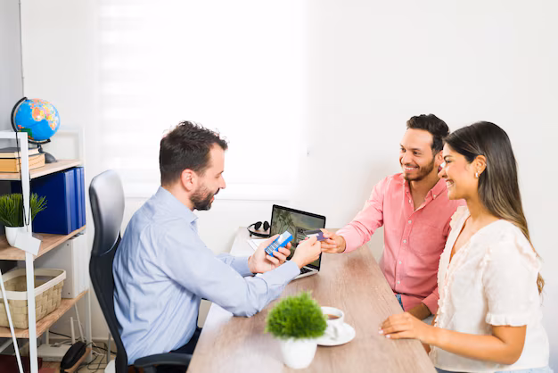 A couple paying for a holiday package by card at a travel agency counter