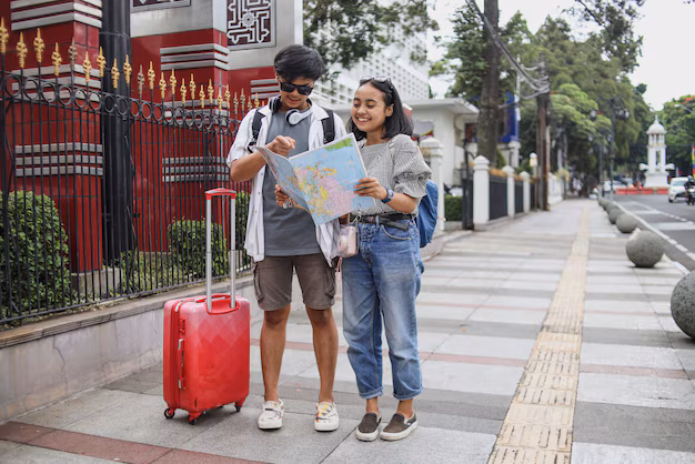 A couple of tourists holding a city map while exploring independently