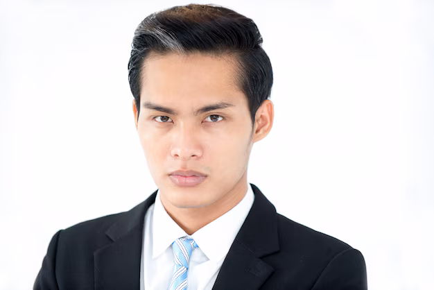 A man looking directly at the camera with a neutral, closed-mouth expression