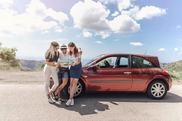 Three friends looking at a map beside a car parked on an open road
