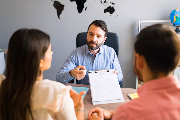 A travel agent going through visa application documents with clients at an office desk